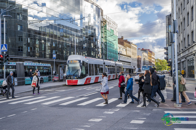 塔林有轨电车穿过市中心,行人正在过马路,展现居民免费公交政策