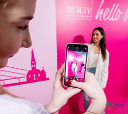 2024年BEAUTY Düsseldorf展会上，一位女性在照片墙前被另一人用手机拍摄；版权：Messe Düsseldorf/Andreas Wiese