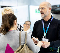 配图：杜塞尔多夫美容展上，专业顾问正向一位参观者讲解产品，背景中另一人专注聆听；版权：杜塞尔多夫展览公司/安德烈亚斯·维泽